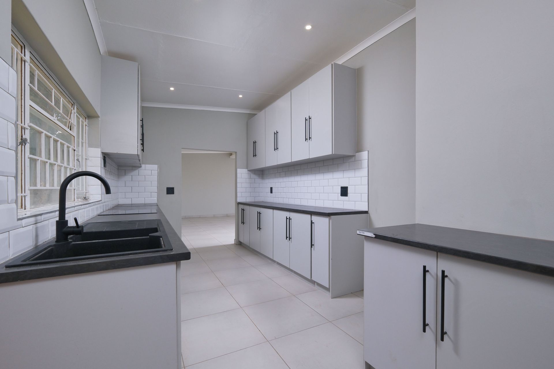 Elegant modern kitchen with sleek design, featuring black appliances and white cabinetry in Pretoria.